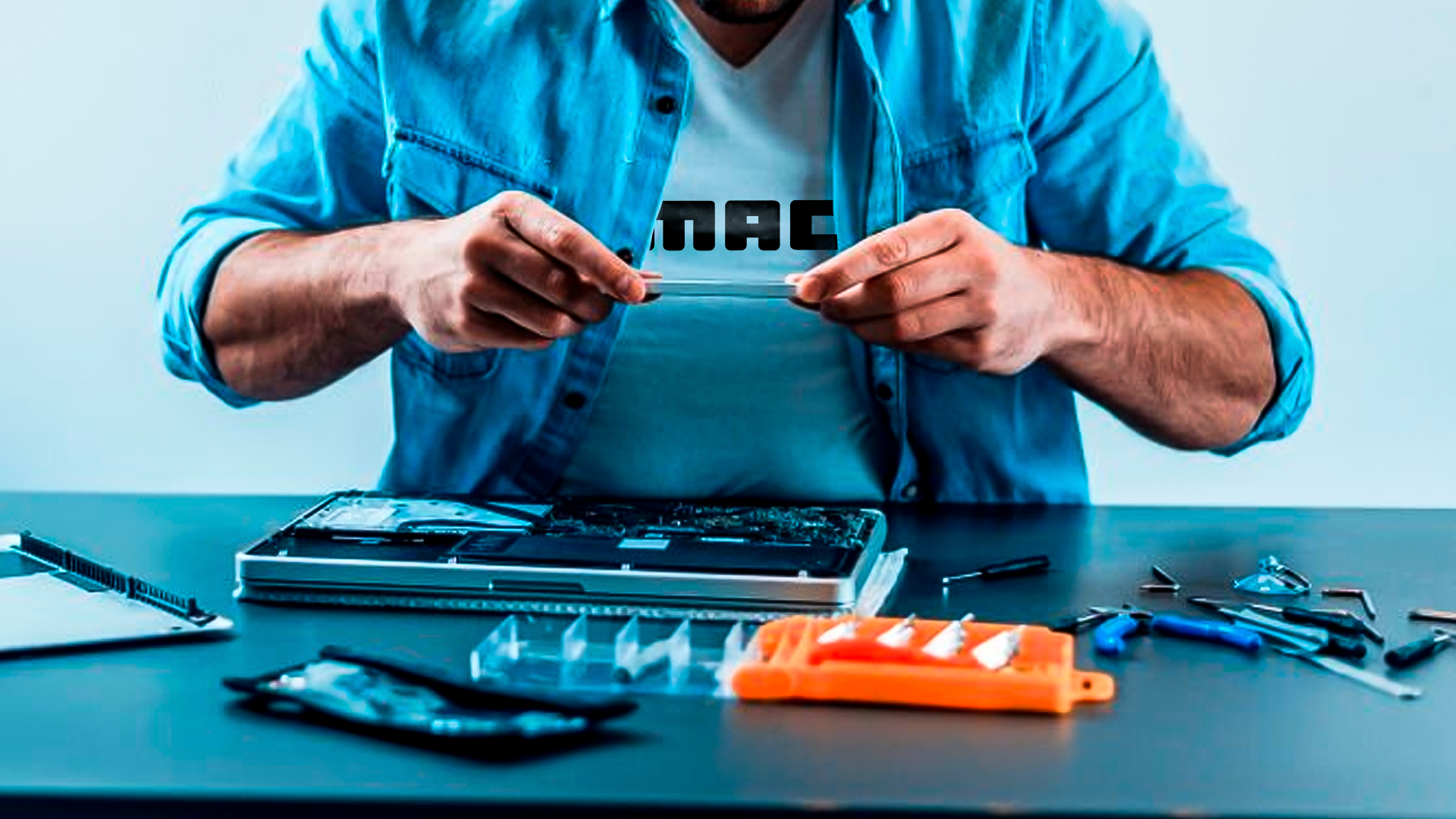 Técnico experiente, com ferramentas adequadas, consertando um notebook que está desmontado em cima da mesa.